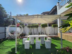 a white table and chairs under a canopy in a yard at D34长住优惠房-芭提雅市中心高端4间卧室泳池别墅 in Pattaya Central