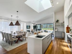 a kitchen and living room with a table and a dining room at Florette's Retreat in Pokolbin