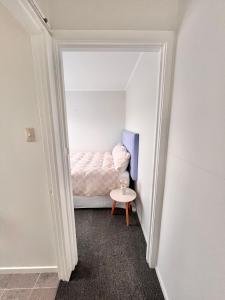 a small bedroom with a bed and a small table at House of Somer in Matamata