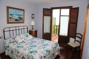 a bedroom with a bed with a floral bedspread at Gane Landetxea in Barrika