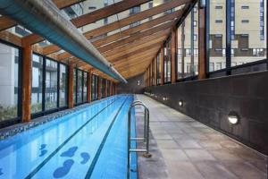 an empty swimming pool with a ramp in a building at Melbourne CBD Apt With A C Balcony & Pool in Melbourne