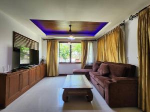 a living room with a couch and a tv at D30长住优惠-市中心海边高端别墅区6间卧室泳池别墅 in Pattaya Central