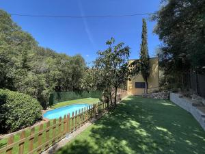 een zwembad in een tuin naast een hek bij Casa Begur, 4 dormitorios, 7 personas - ES-226-1 in Begur