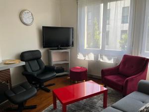 a living room with two chairs and a tv at Appartement Royan, 3 pièces, 4 personnes - FR-1-539-52 in Royan