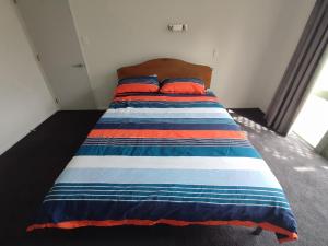 a bed with two pillows on it in a room at panoramic vista with sea views in New Plymouth