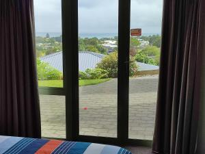 a room with a window with a view of a driveway at panoramic vista with sea views in New Plymouth