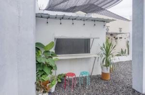 a balcony with two stools and a tv on a wall at Oemah Ratu Hostel Syariah RedPartner in Bandar Lampung