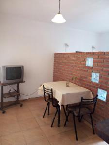 Habitación con mesa, sillas y TV. en Monoambiente Carlos Paz en Villa Carlos Paz