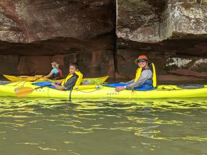 tres personas en un kayak amarillo en el agua en Hidden Gem, 3 Bed Cozy Condo - Dogs Welcomed, en Bayfield