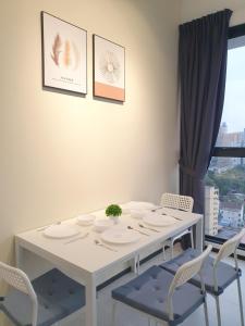 ein weißes Esszimmer mit einem weißen Tisch und Stühlen in der Unterkunft Seaview Infinity Retreat Urban Suite 3R2B 8Pax Georgetown in Jelutong
