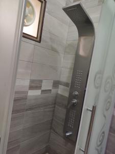 La salle de bains est pourvue d'une porte de douche avec un pommeau de douche. dans l'établissement Lotus housing for furnished apartments, à Jerash