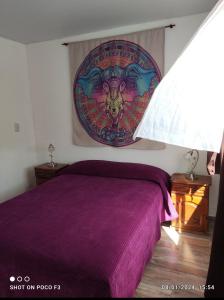 a bedroom with a purple bed with a painting on the wall at Alquimia Qi del Mar in Mar de Cobo