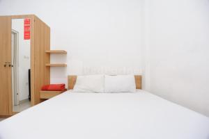 雅加達的住宿－Family Residence Redpartner，卧室配有一张白色大床和一个衣柜