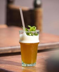 een glas bier zittend op een houten tafel bij Hôtel Riad Atlas Dades in Boumalne