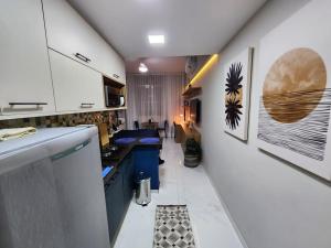 a small kitchen with white cabinets and blue appliances at Copa Alegria - Conforto, praia e comodidade in Rio de Janeiro