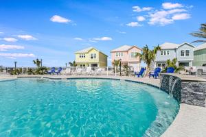 a swimming pool with blue chairs in front of houses at Fishtastic SP103 in Rockport