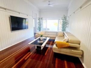 ein Wohnzimmer mit einem Sofa und einem Tisch in der Unterkunft Exclusive location - Entire 3-bedroom in Maryborough CBD, 10ppl in Maryborough