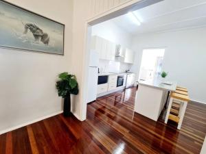 a living room with a kitchen and a table at Exclusive location - 3-bedroom Unit in Maryborough CBD, 10ppl in Maryborough