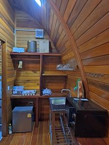 a kitchen with a sink in a room with wooden walls at Seaview Eagles Nest Cabins in Rawai Beach