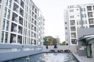 a swimming pool in the middle of two buildings at Blue and green Farang homes in Chiang Mai