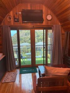 a living room with a large window and a tv at Seaview Eagles Nest Cabins in Rawai Beach