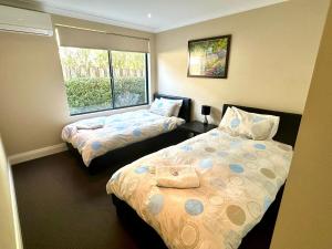 a bedroom with two beds and a window at Ocean View Executive Apartment 1 in Busselton
