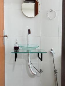 a bathroom with a glass sink and a mirror at FRAN's - HOSPEDAGENS in Lagoa Santa