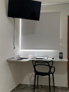 a table with a chair and a white counter top at FRAN's - HOSPEDAGENS in Lagoa Santa