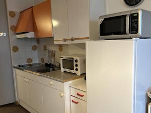 Il comprend une petite cuisine équipée d'un four micro-ondes et d'un réfrigérateur. dans l'établissement Appartement Balaruc-les-Bains, 1 pièce, 2 personnes - FR-1-680-36, à Balaruc-les-Bains