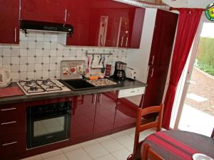cocina con armarios rojos y fogones en Gîte Fiennes, 3 pièces, 5 personnes - FR-1-376-118, en Fiennes