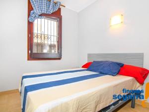 a bed in a room with a window at Apartamento Roda de Berà, 3 dormitorios, 6 personas - ES-320-5 in Roda de Bará