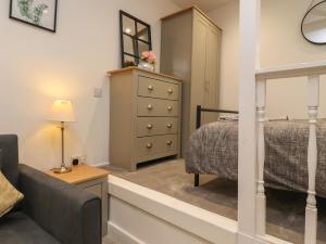 a bedroom with a bed and a dresser at Basement Flat 43 in Keighley
