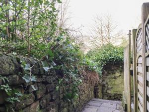 a stone wall with a gate and a walkway at Basement Flat 43 in Keighley