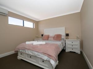 - une chambre avec un grand lit et une fenêtre dans l'établissement Ocean View Executive Apartment 4, à Geographe