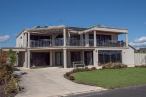 Une grande maison blanche avec balcon est située dans une rue. dans l'établissement Ocean View Executive Apartment 4, à Geographe