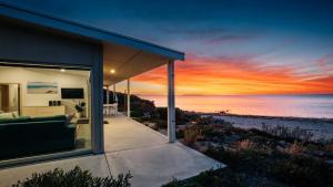 a house with a view of the beach at sunset at Beachside in Coffin Bay