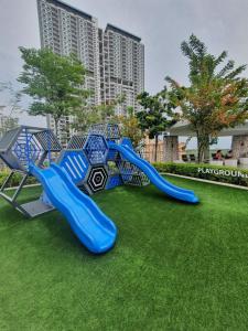 einen Spielplatz mit einer blauen Rutsche auf dem Rasen in der Unterkunft Seaview Infinity Retreat Urban Suite 3R2B 8Pax Georgetown in Jelutong