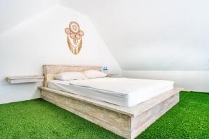 a bed in a room with green grass at Anny Guesthouse by ecommerceloka in Darmasaba