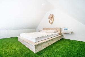 a bedroom with a bed with green grass at Anny Guesthouse by ecommerceloka in Darmasaba
