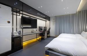 - une chambre avec un lit et un bureau avec un ordinateur dans l'établissement Reina Hotel, à Busan