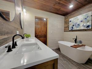a bathroom with a tub and a large white sink at A Splashing Good Time in Sevierville +39 photos