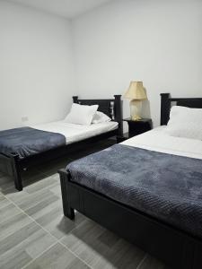 dos camas sentadas una al lado de la otra en una habitación en Zavara Hostal, en Pueblo Tapado