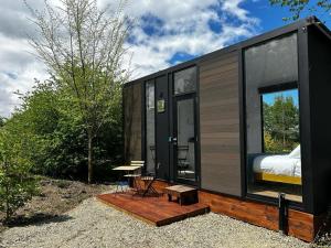 a black tiny house with a bed and a table at Tiny Away Benger Garden 2 in Millers Flat