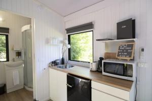 a small kitchen with a microwave and a sink at Tiny Away Benger Garden 2 in Millers Flat