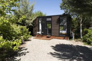 a black tiny house in the middle of a yard at Tiny Away Benger Garden 2 in Millers Flat