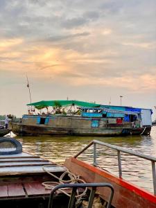 a couple of boats are docked in the water at Dan Sinh Homestay in Can Tho