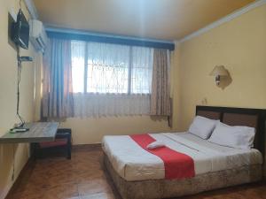 a bedroom with a large bed with a window at RedDoorz Syariah At Hotel Matahari 1 Jambi in Jambi