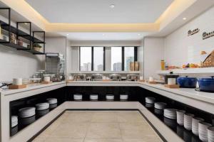 a large kitchen with a counter with plates on it at Nihao Hotel Quanzhou Donghu Street in Quanzhou