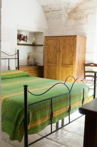 マルティナ・フランカにあるLapignagiallaのベッドルーム1室(ベッド1台付)、木製キャビネットが備わります。