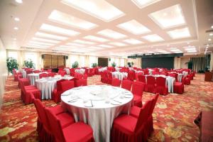 une salle de banquet avec des tables blanches et des chaises rouges dans l'établissement Madison Lanzhou Lanshi Zhongchuan Airport, à Hejialiang